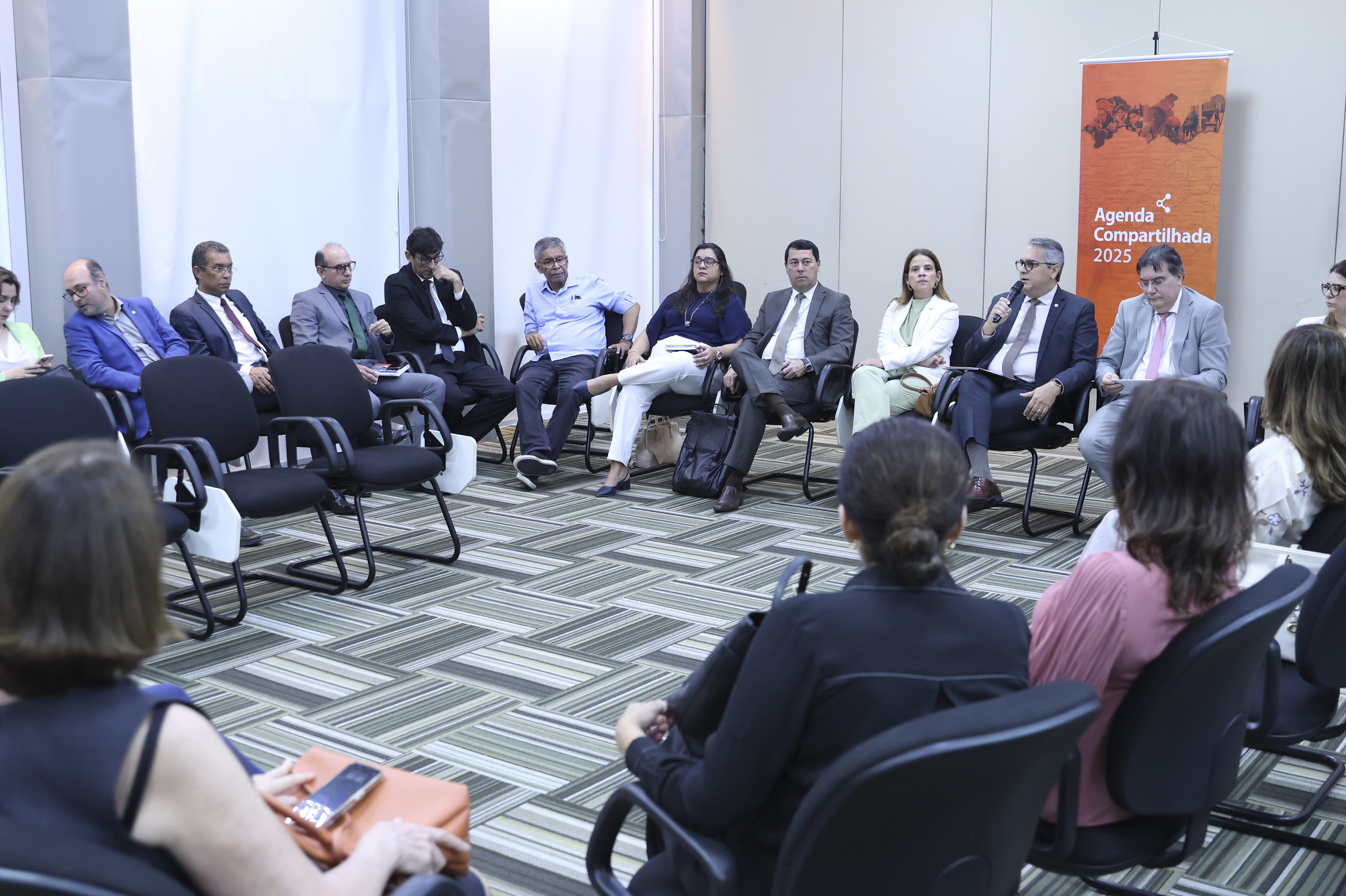 Fotografia de participantes do evento sentados em círculo