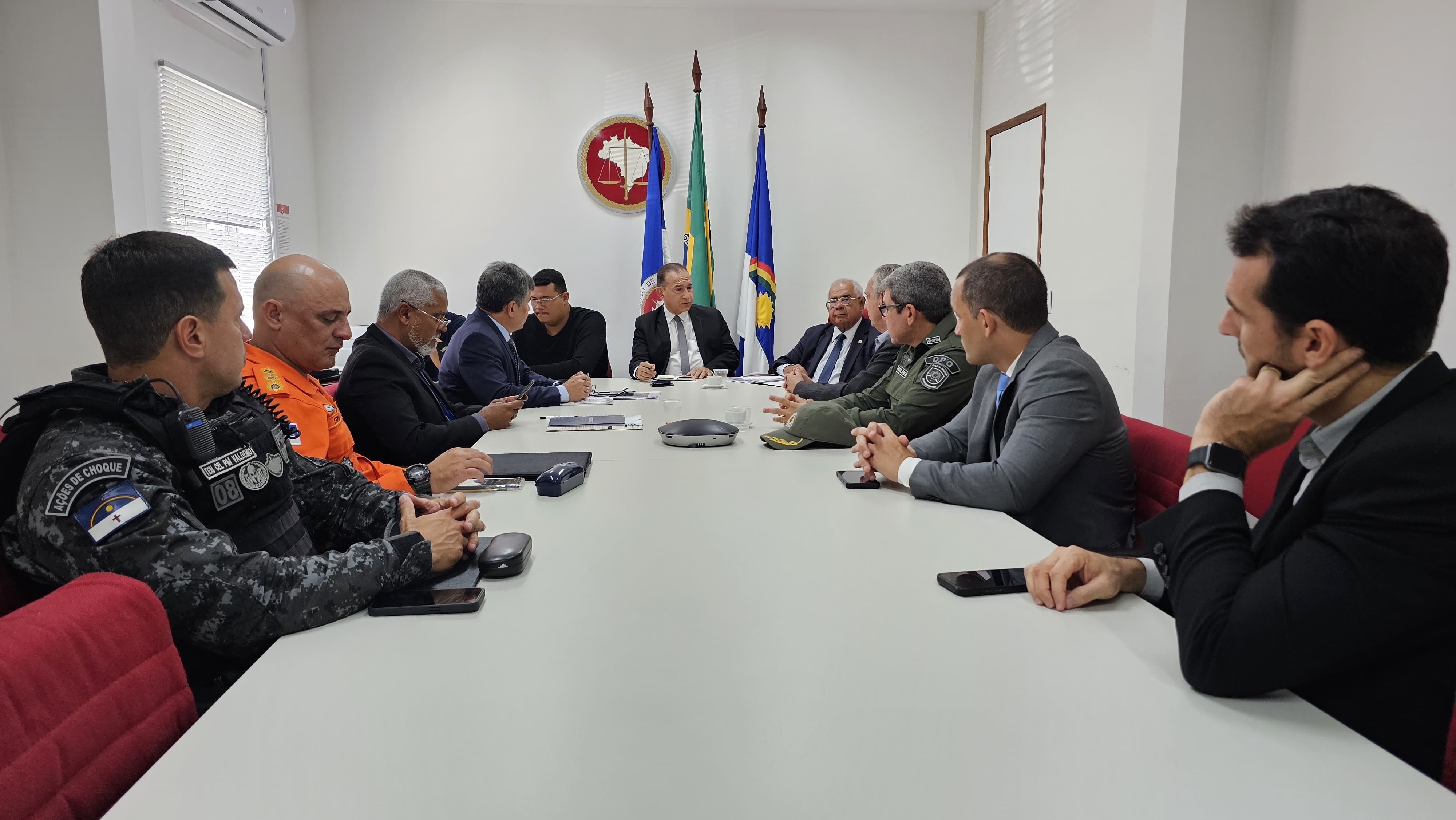 Fotografia de participantes da reunião sentado à mesa de discussão